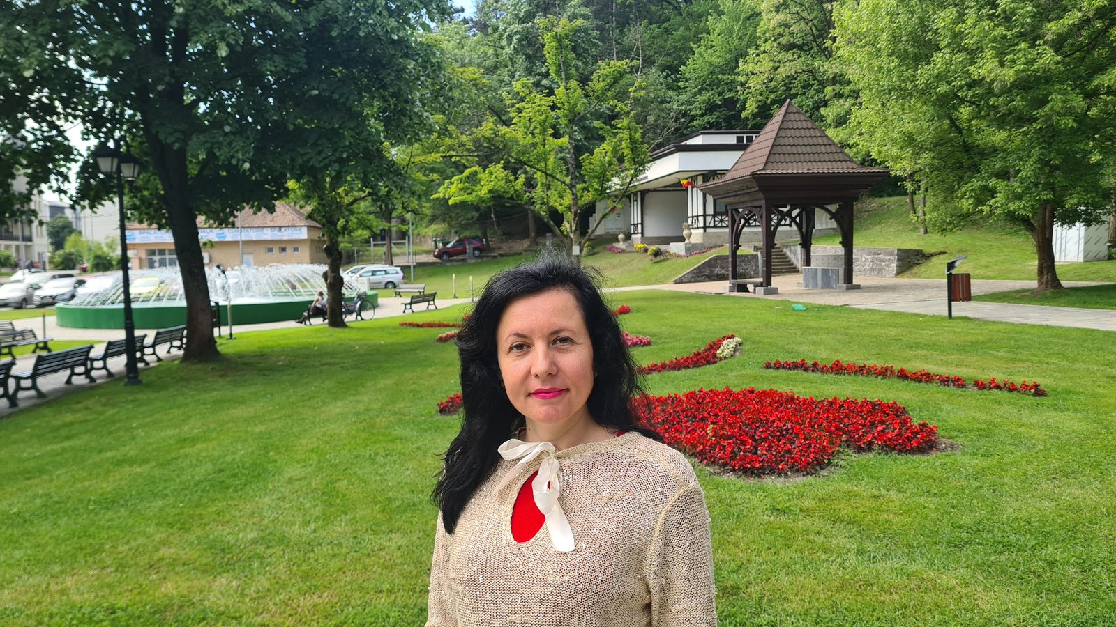 În parc, lângă rondul de flori roșii